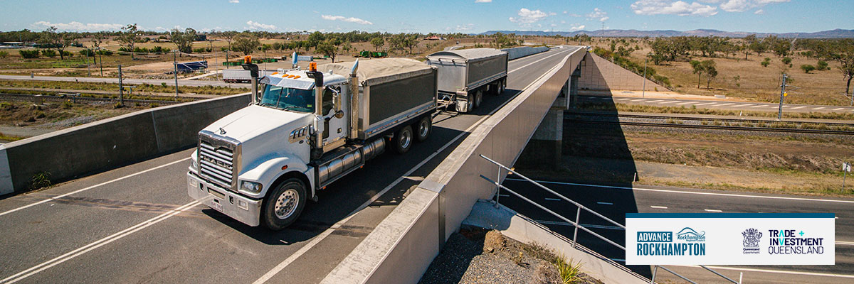 A truck with two trailers drives over an overpass